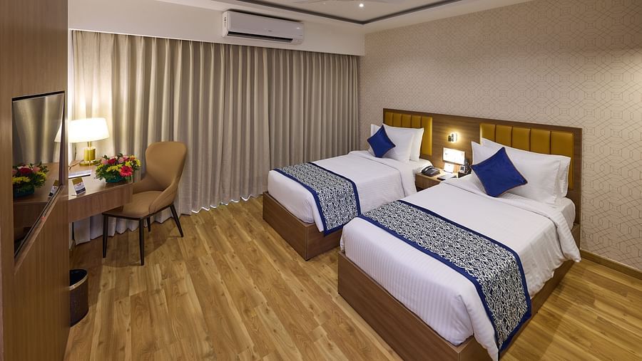 A cosy hotel room setup with two beds and a work desk - Grand Continent, Brookefield