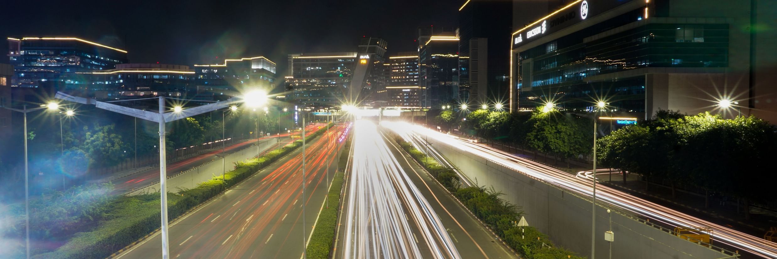 a long exposure picture taken of a road in live mode showing long trails of car lights captured during the night