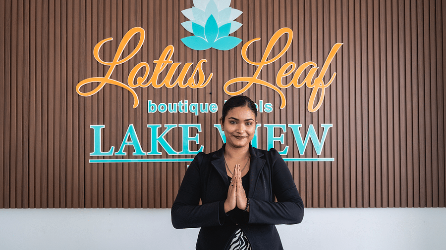 A woman joining hands and welcoming guests to Lotus Leaf Boutique Hotel
