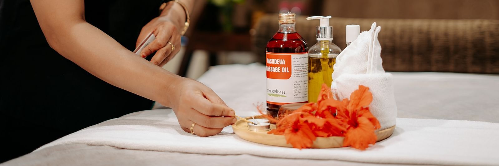 A lady neatly arranging all the essential spa equipment on the bed at Crescent Spa & Resort, Indore