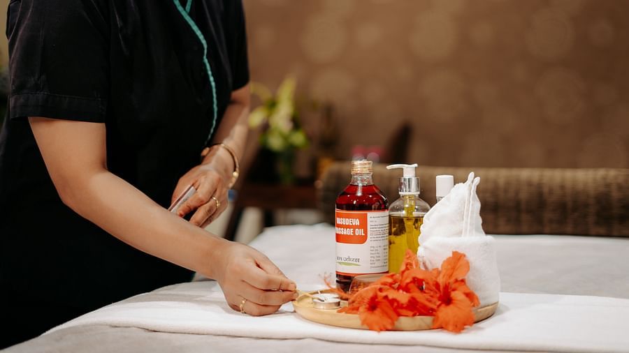 A lady neatly arranging all the essential spa equipment on the bed at Crescent Spa & Resort, Indore