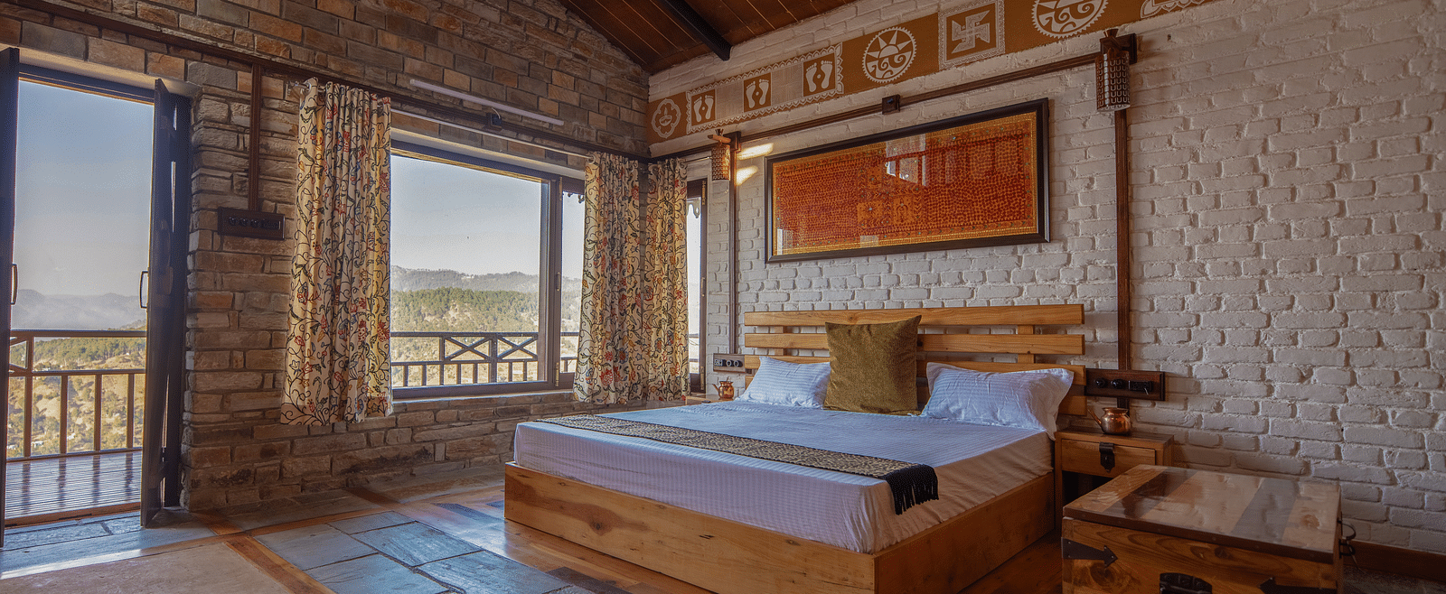 Room seating area with two wooden chairs, a rustic table, and a large window offering panoramic views of the lush mountains. - Blusalzz Homes The Himalayan Bungalow, Almora