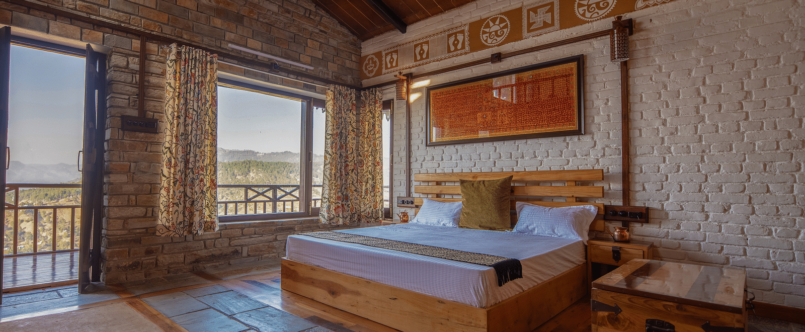 Room seating area with two wooden chairs, a rustic table, and a large window offering panoramic views of the lush mountains. - Blusalzz Homes The Himalayan Bungalow, Almora