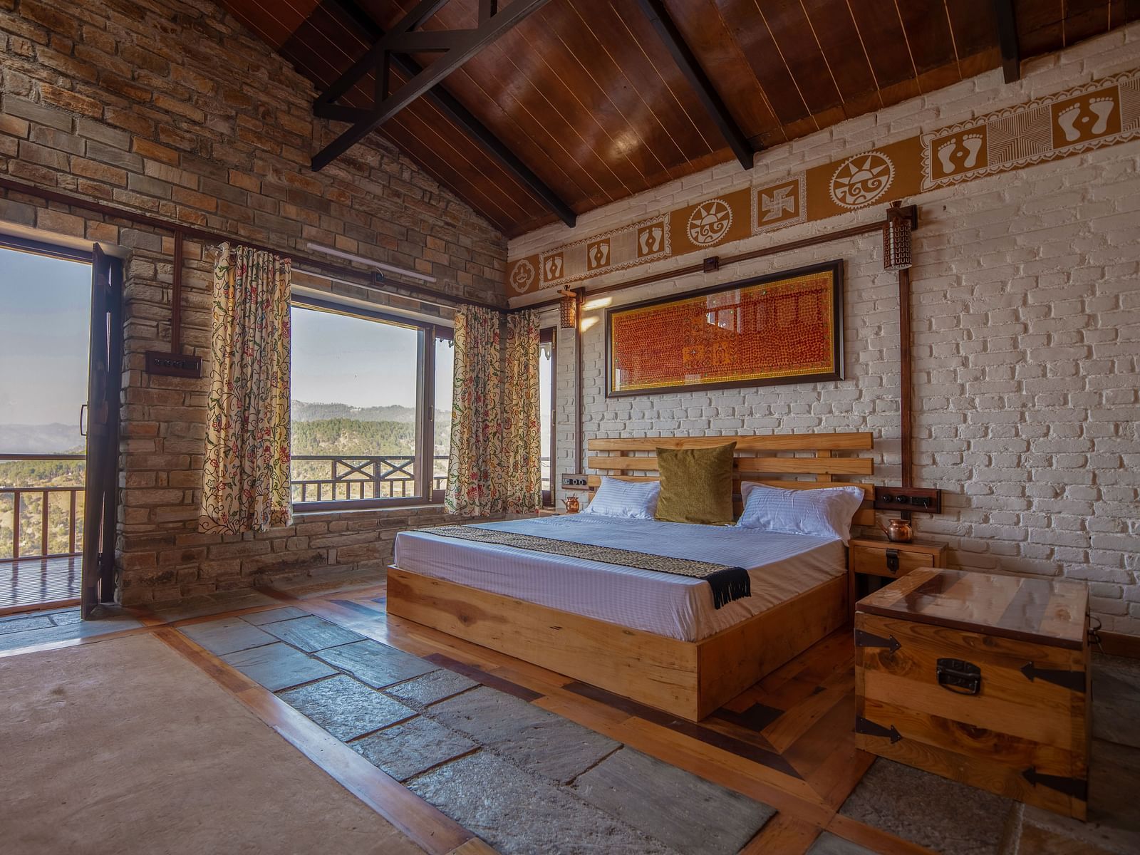 Room seating area with two wooden chairs, a rustic table, and a large window offering panoramic views of the lush mountains. - Blusalzz Homes The Himalayan Bungalow, Almora