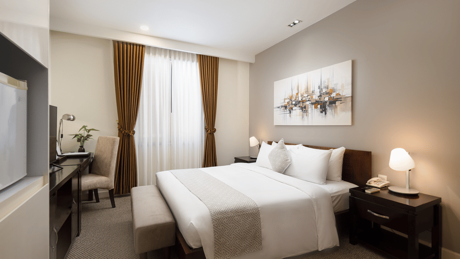 Spacious Studio with Workspace at Central Mansions, Phnom Penh featuring a queen bed, bedside tables, work area, and comfortable interiors.