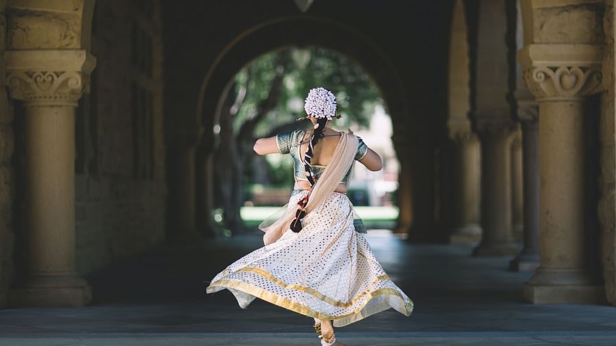 a girl dancing in an ancient hallway