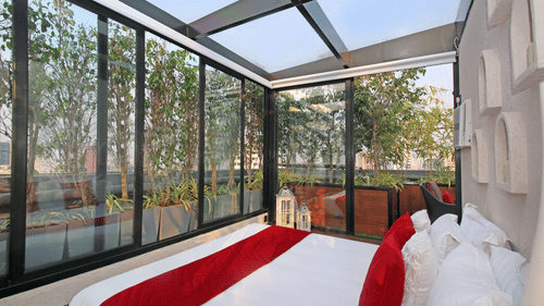 An image of a bedroom with glass windows and ceilings at Theory9 - Premium Service Apartments, Bandra