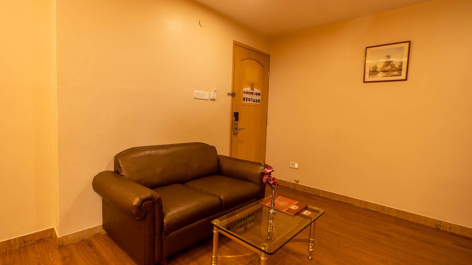 A couch inside a room with a table in front of it at Hotel Pai Viceroy Jayanagar