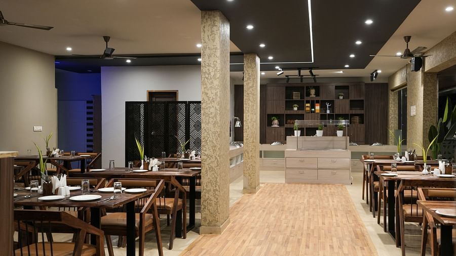 Central walkway between dining tables leading to the buffet counter at the far end at TGI Livancia Hillside, JC Nagar, Mysore
