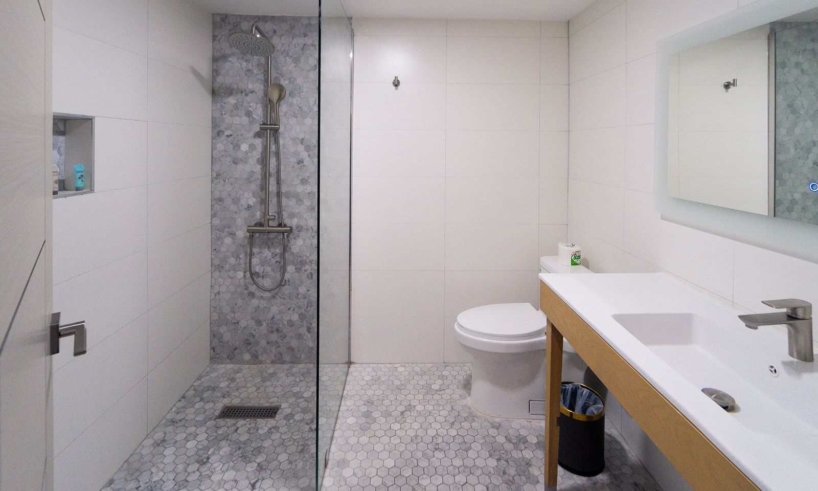 A spacious bathroom featuring a clean design with white tiles and a walk-in shower - Hotel 39, Jamaica