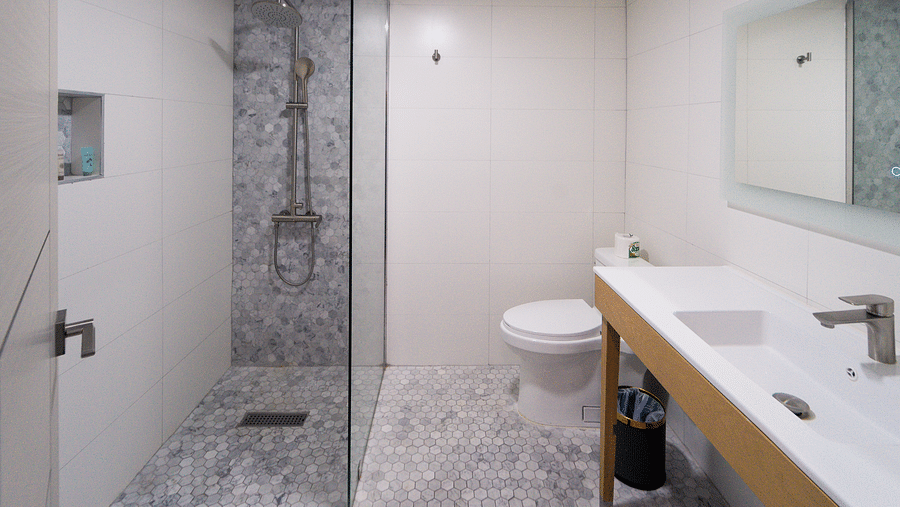 A spacious bathroom featuring a clean design with white tiles and a walk-in shower - Hotel 39, Jamaica