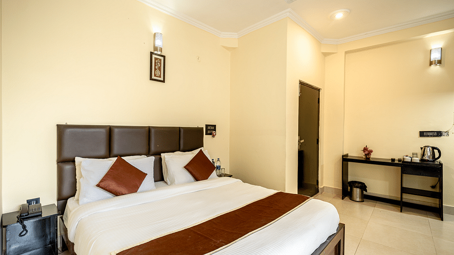 a bedroom at Flutter Hotels & Resorts featuring a bed and desk with kettle