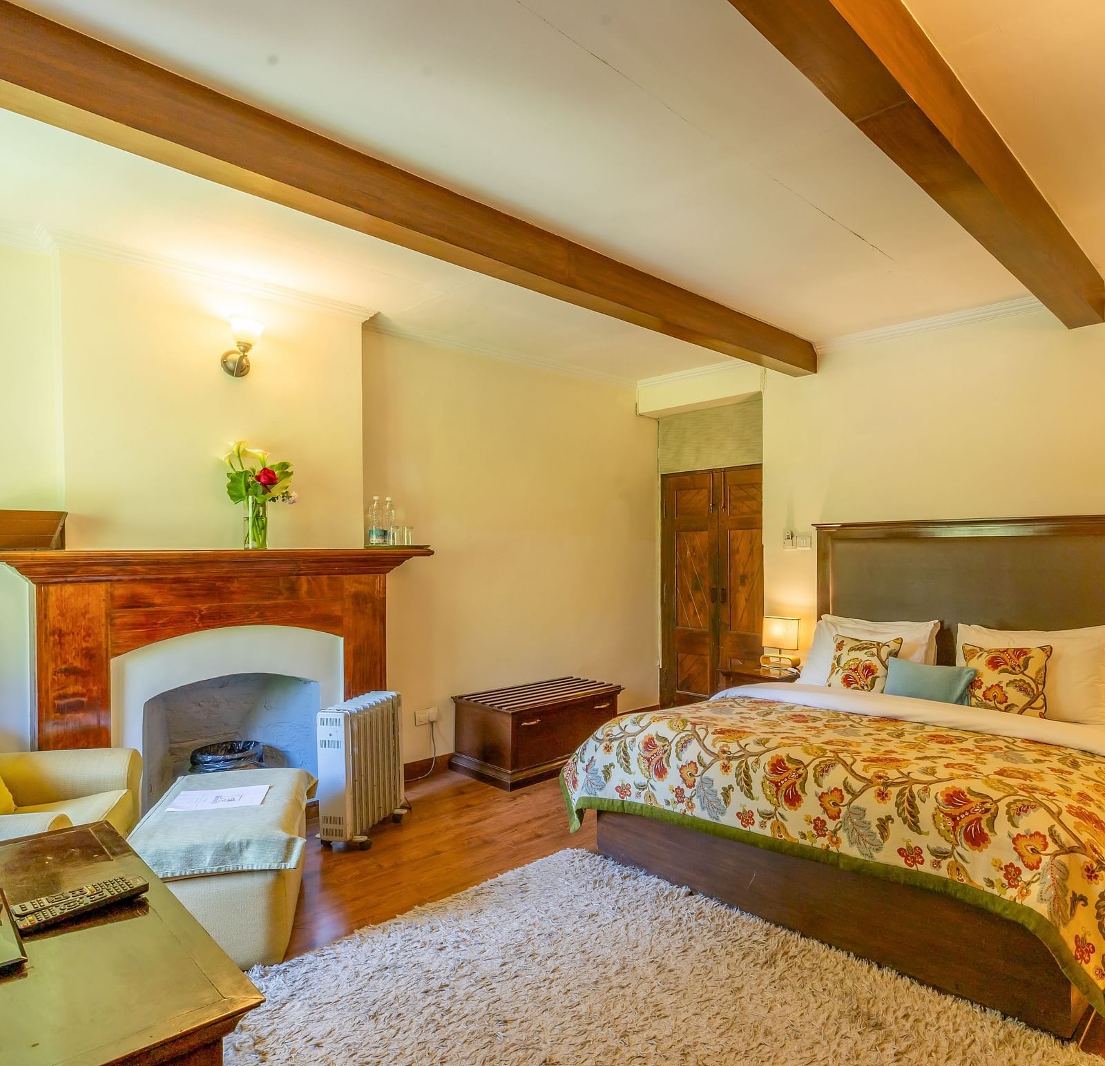 deluxe room with queen bed and TV and a sofa at Bedzz Xclusiv Baikunth, Manali