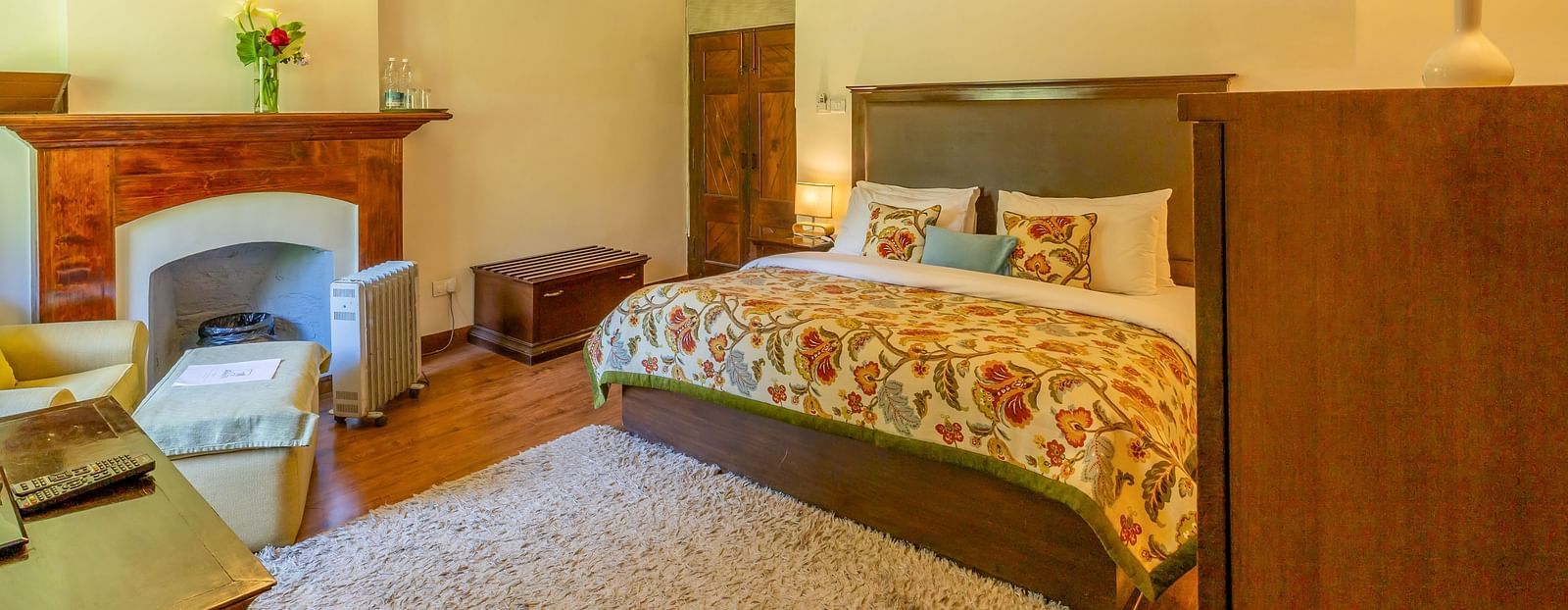 deluxe room with queen bed and TV and a sofa at Bedzz Xclusiv Baikunth, Manali