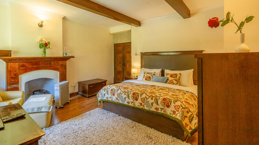 deluxe room with queen bed and TV and a sofa at Bedzz Xclusiv Baikunth, Manali