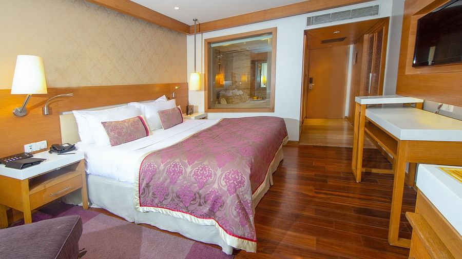 room with king size bed and wooden flooring at hotel bawa international