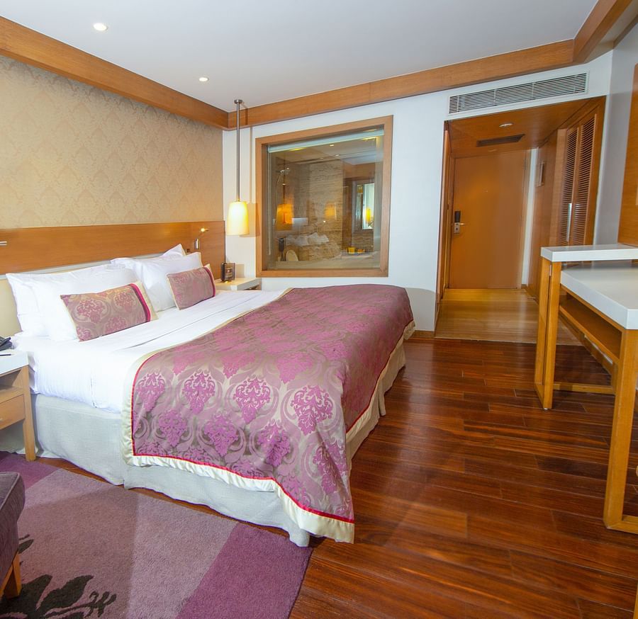 room with king size bed and wooden flooring at hotel bawa international
