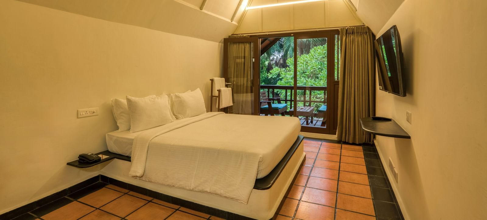 Thai Cottage Bedroom  with V shaped ceiling, a balcony and a bed.