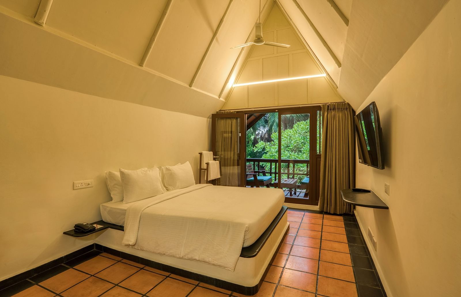 Thai Cottage Bedroom  with V shaped ceiling, a balcony and a bed.