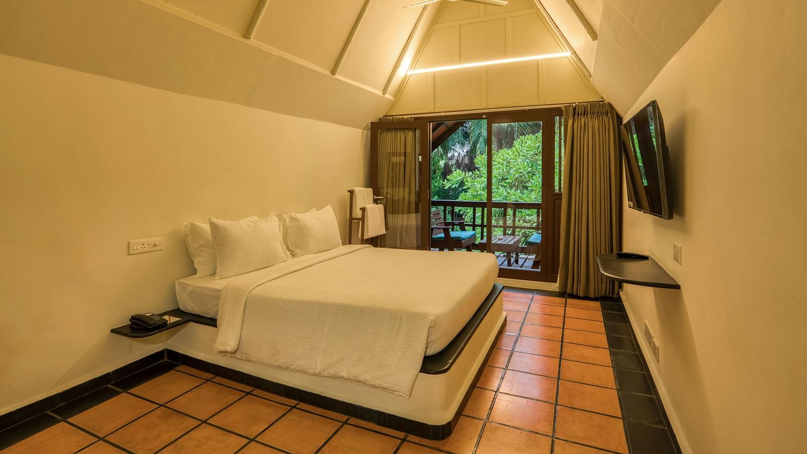 Thai Cottage Bedroom  with V shaped ceiling, a balcony and a bed.