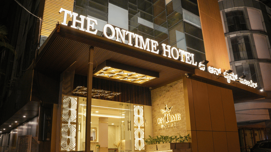 Entrance of The OnTime Bangalore in Ashok Nagar featuring well lit stairs and next to it there are flower pots leading to the lobby of the hotel. 