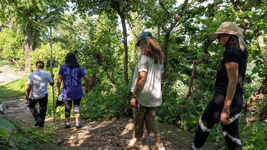 a group of people in a forest on a hike - Neer Ganga Resorts