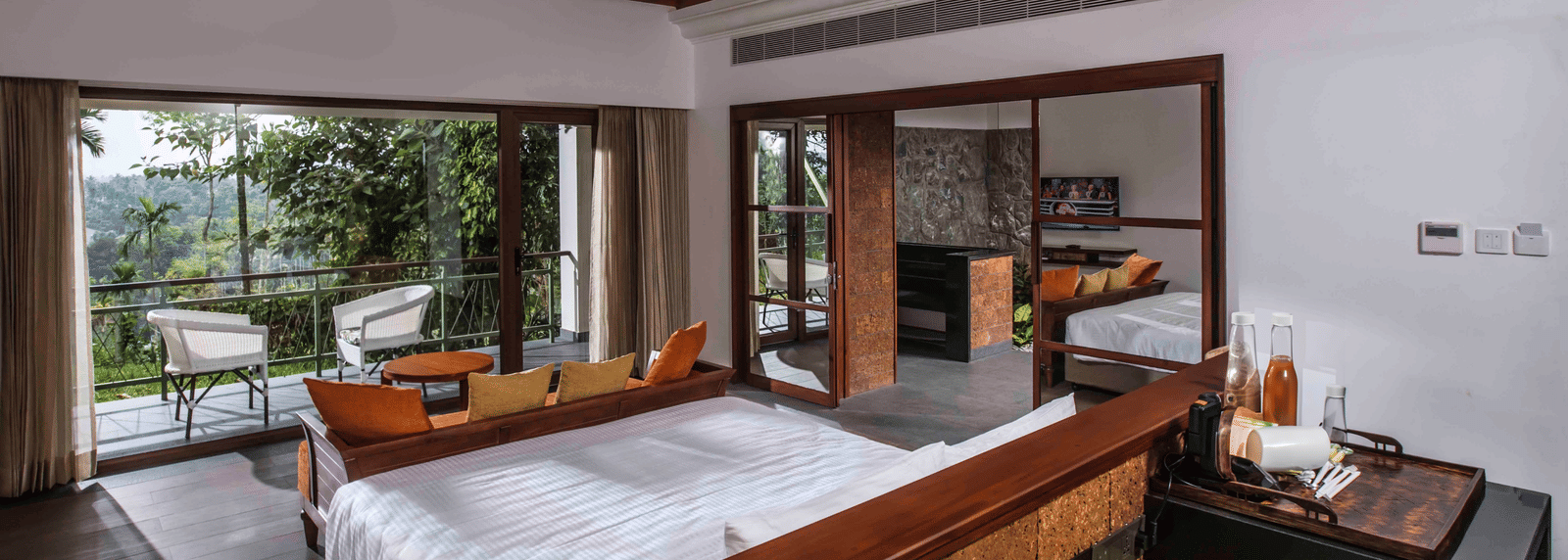 A room in Wayanad with a bed facing the beautiful view outside the room - GReaT trails Wayanad by GRT Hotels