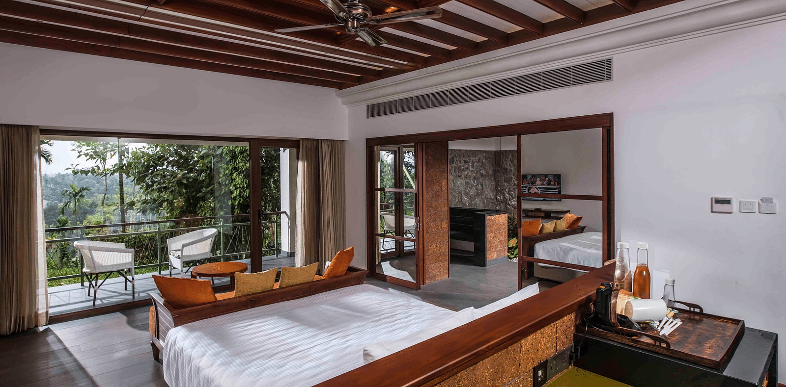 A room in Wayanad with a bed facing the beautiful view outside the room - GReaT trails Wayanad by GRT Hotels
