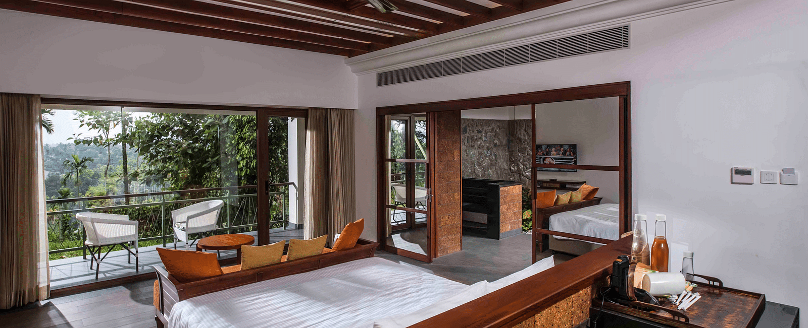 A room in Wayanad with a bed facing the beautiful view outside the room - GReaT trails Wayanad by GRT Hotels