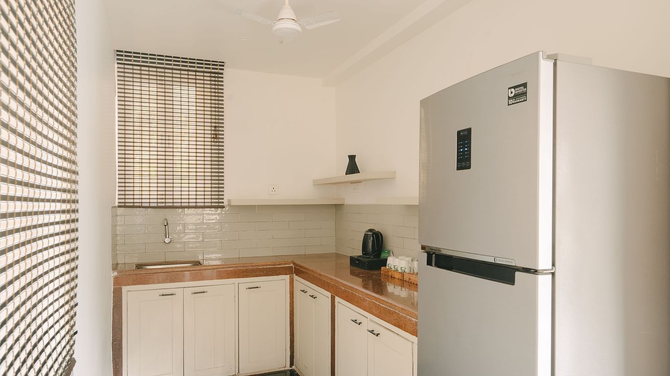 Modern kitchen with sleek cabinets and a large refrigerator in Three BHK Premium Villa, Richmonde Ananta Elite, Goa.
