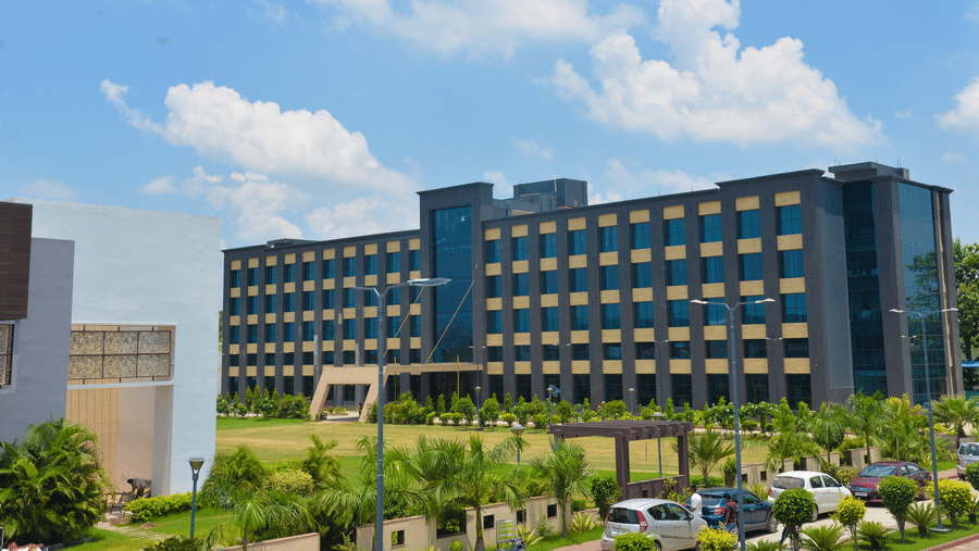 Facade of Golden Blossom Imperial Resorts featuring a modern multi-storey main building surrounded by green lawns, palm trees, parked vehicles
