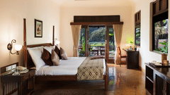 An image of Premium Room featuring a double size bed, a bedside table, a work desk and chair, a cabinet table, and a flat TV screen at Jehan Numa Restreat