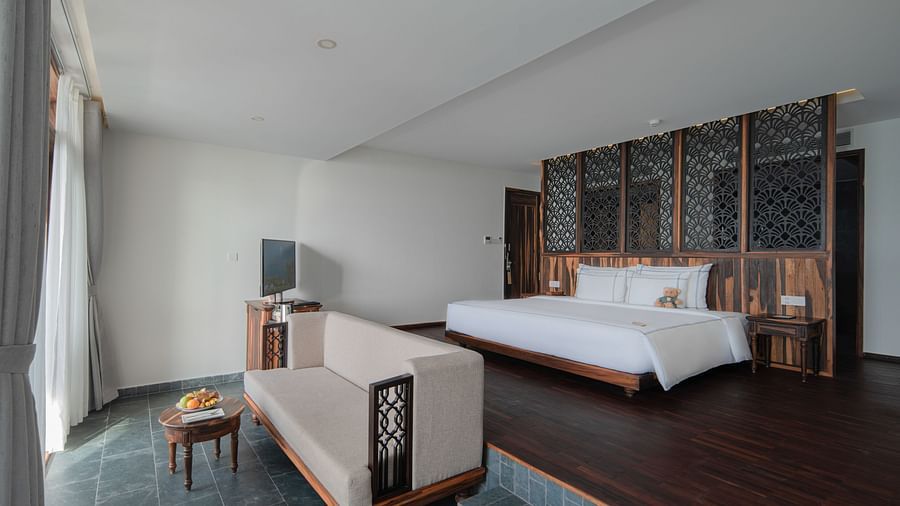 A view of our rooms with a plush bed situated in top of an elevated platform - Alibu Resort Nha Trang