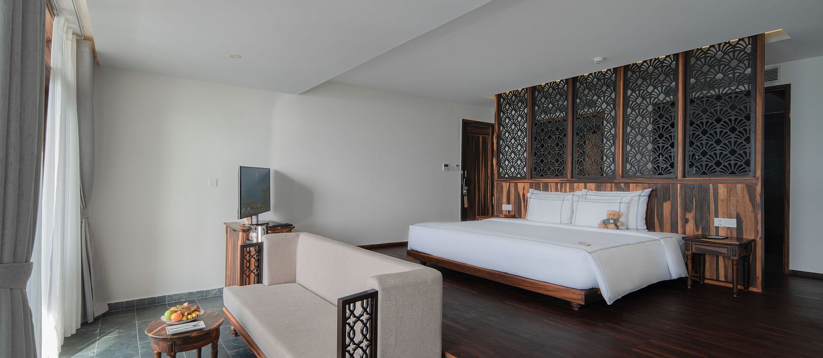 A view of our rooms with a plush bed situated in top of an elevated platform - Alibu Resort Nha Trang