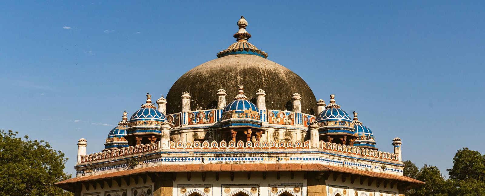 Front view exterior shot of Ibrahim Lodi's tomb with a bright blue sky in the background.