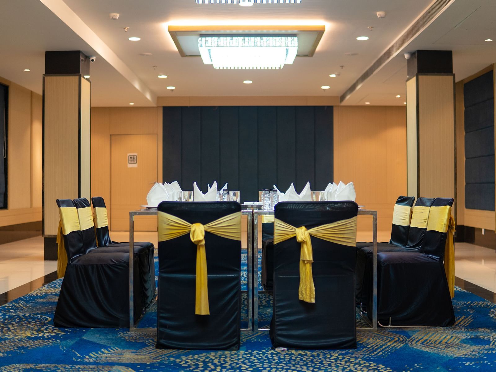 a hall with a square table and decorated chairs surrounding it - Jardin Hotels, Indore