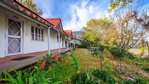 Exterior of the bungalows during the day with greenery around - Ramgarh Bungalows, Nainital.