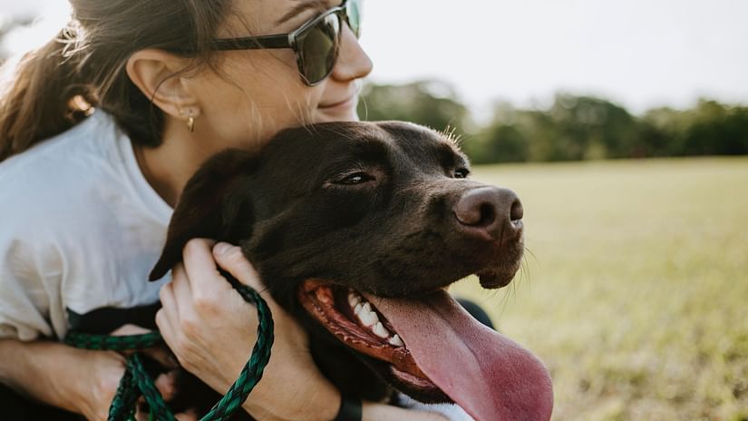 a pet owner embracing her dog