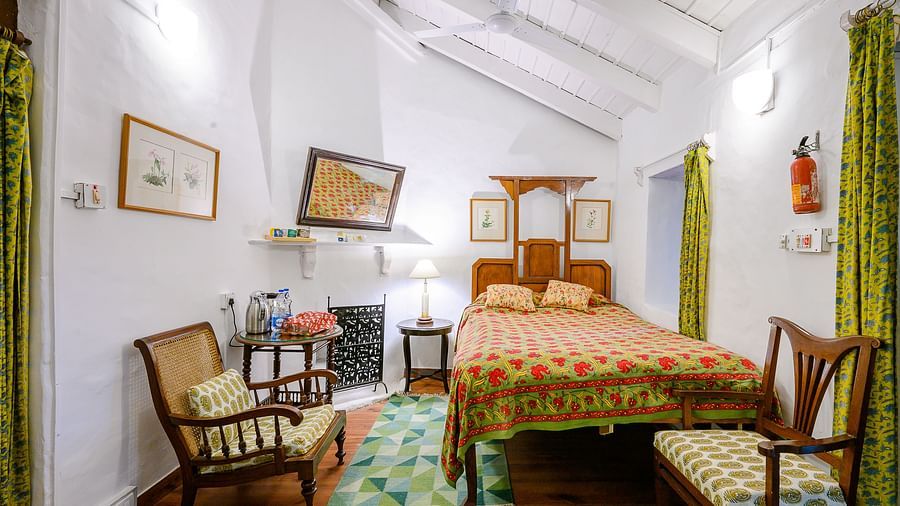 Kashmir room with queen size bed, a chair and paintings - Ramgarh Bungalows, Nainital