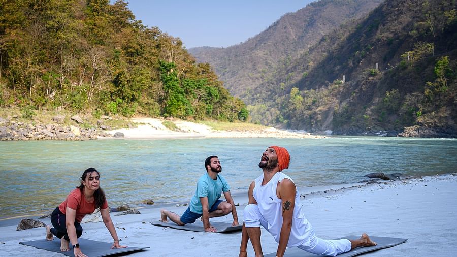 Visitors performing yoga on a beach