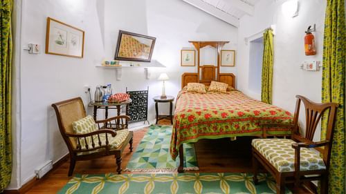 Room with a single queen sized bed and two chairs next to the bed - Ramgarh Bungalows, Nainital.