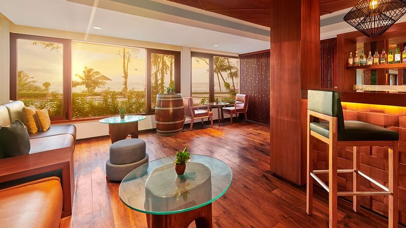 A coffee table in the centre with a leather sofa on the side inside the Upper deck Bar - The Resort, Mumbai