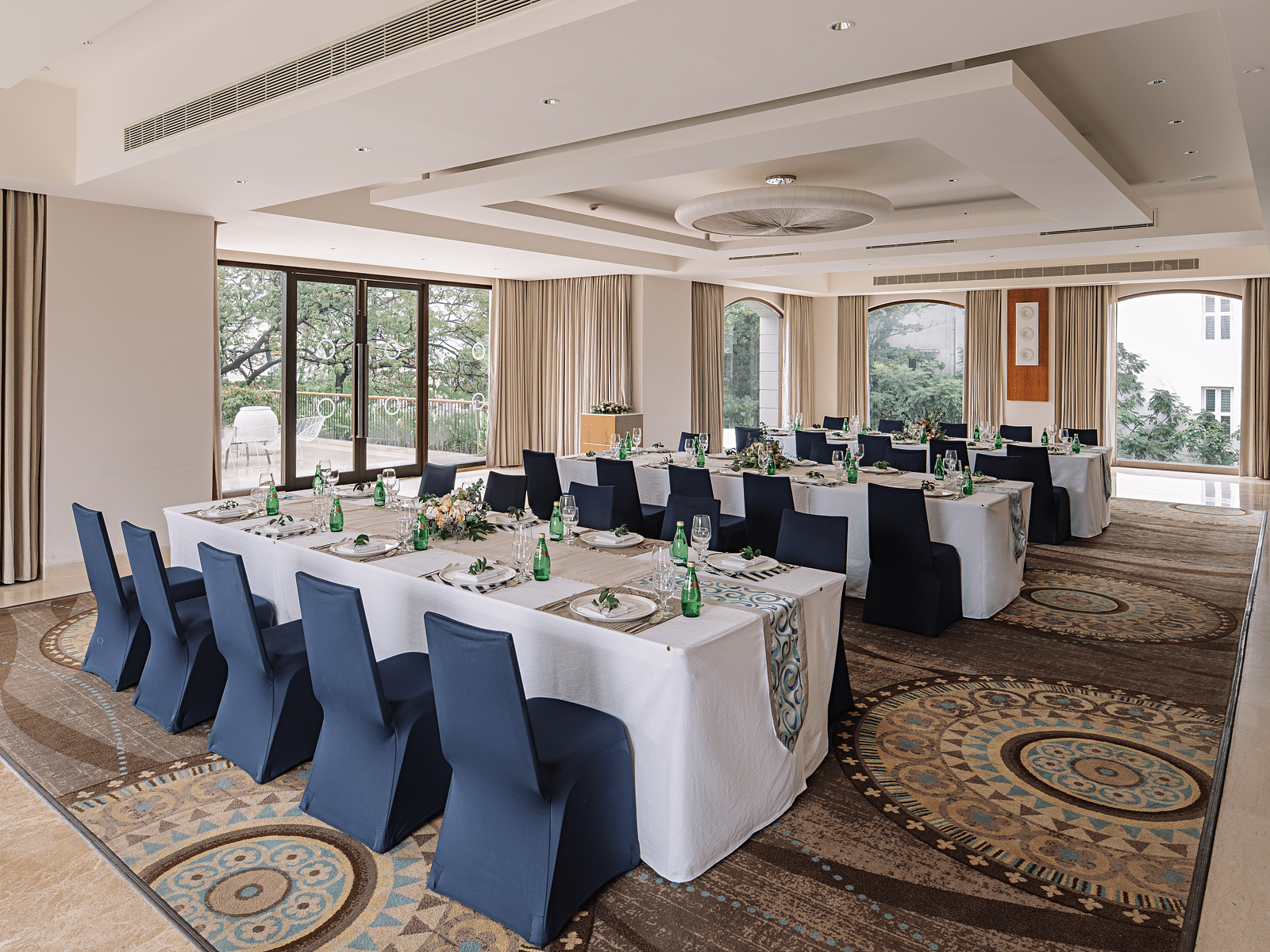A hall with a rectangle table with chairs arranged beside it at The Raintree Hotel, St. Mary's Road.