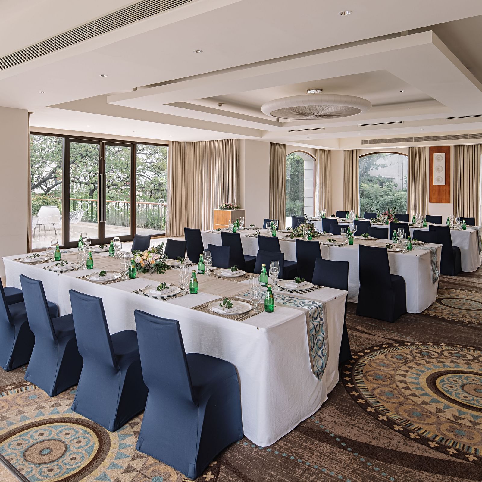 A hall with a rectangle table with chairs arranged beside it at The Raintree Hotel, St. Mary's Road.