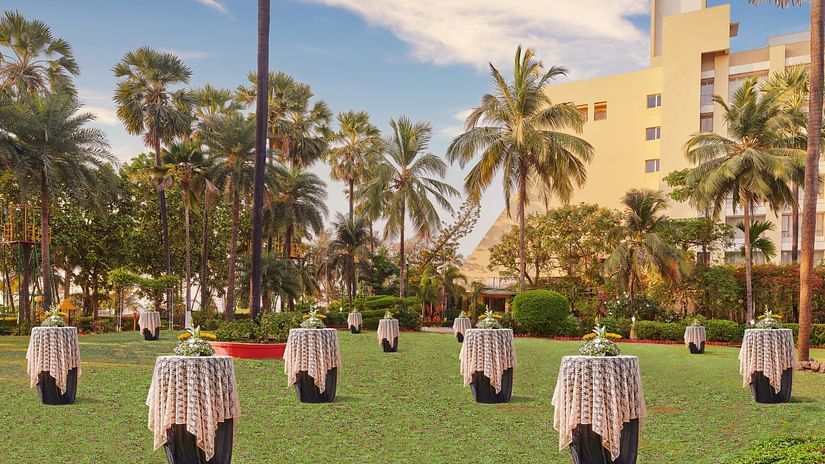 many tables with a vase and bouquet kept on top of it on the RBC Lawn - The Resort, Mumbai