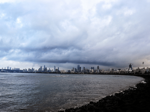 An overview of Marine Drive in Mumbai as seen during daytime with dark clouds above.