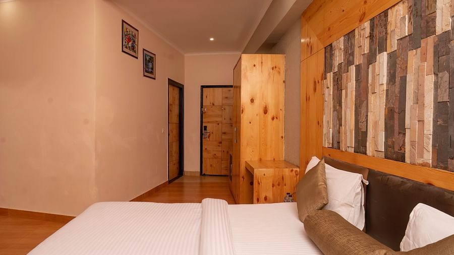 A room with a king bed and wall decor at The Tattwaa Corbett Spa & Resort.
