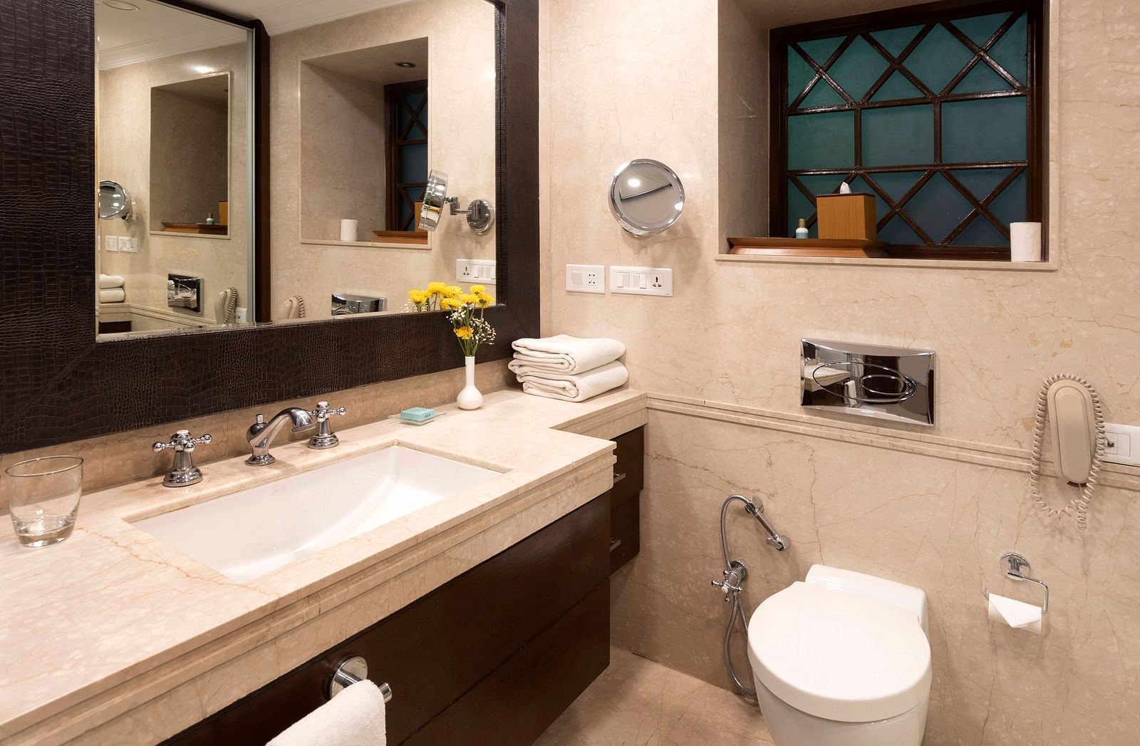image of the sink and with a huge mirror in a bathroom at The Claridges Nabha Residence