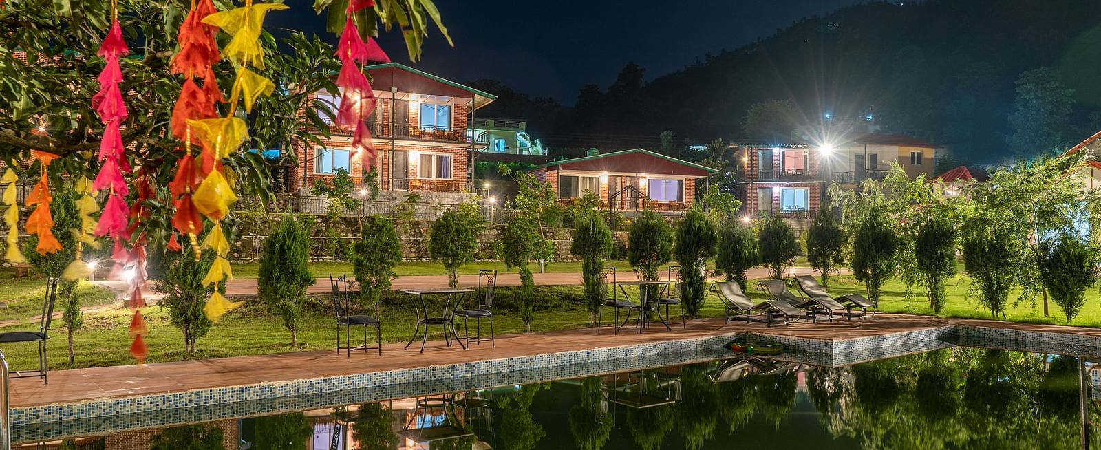 swimming pool in view with plants covering and neer ganga resorts in the background