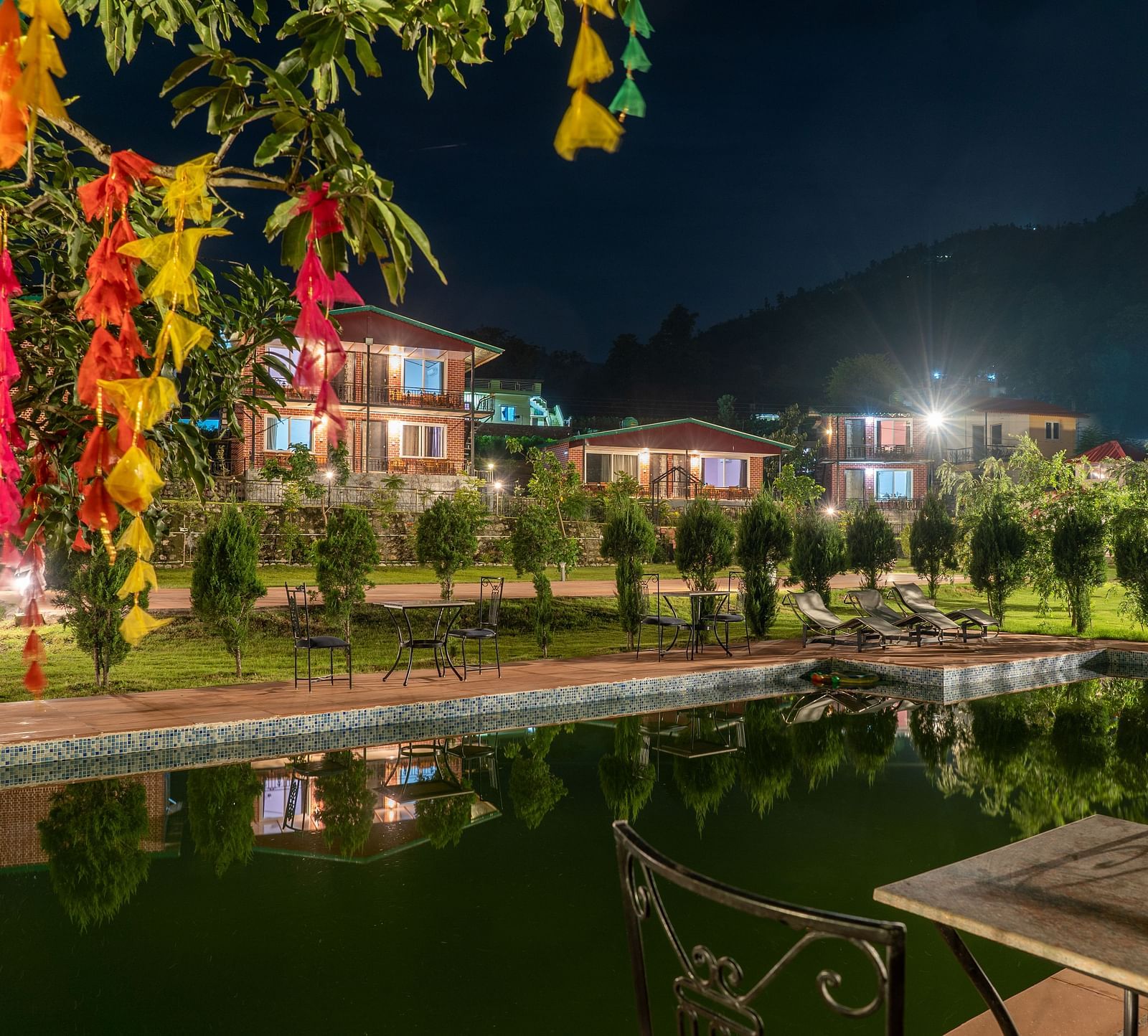 swimming pool in view with plants covering and neer ganga resorts in the background